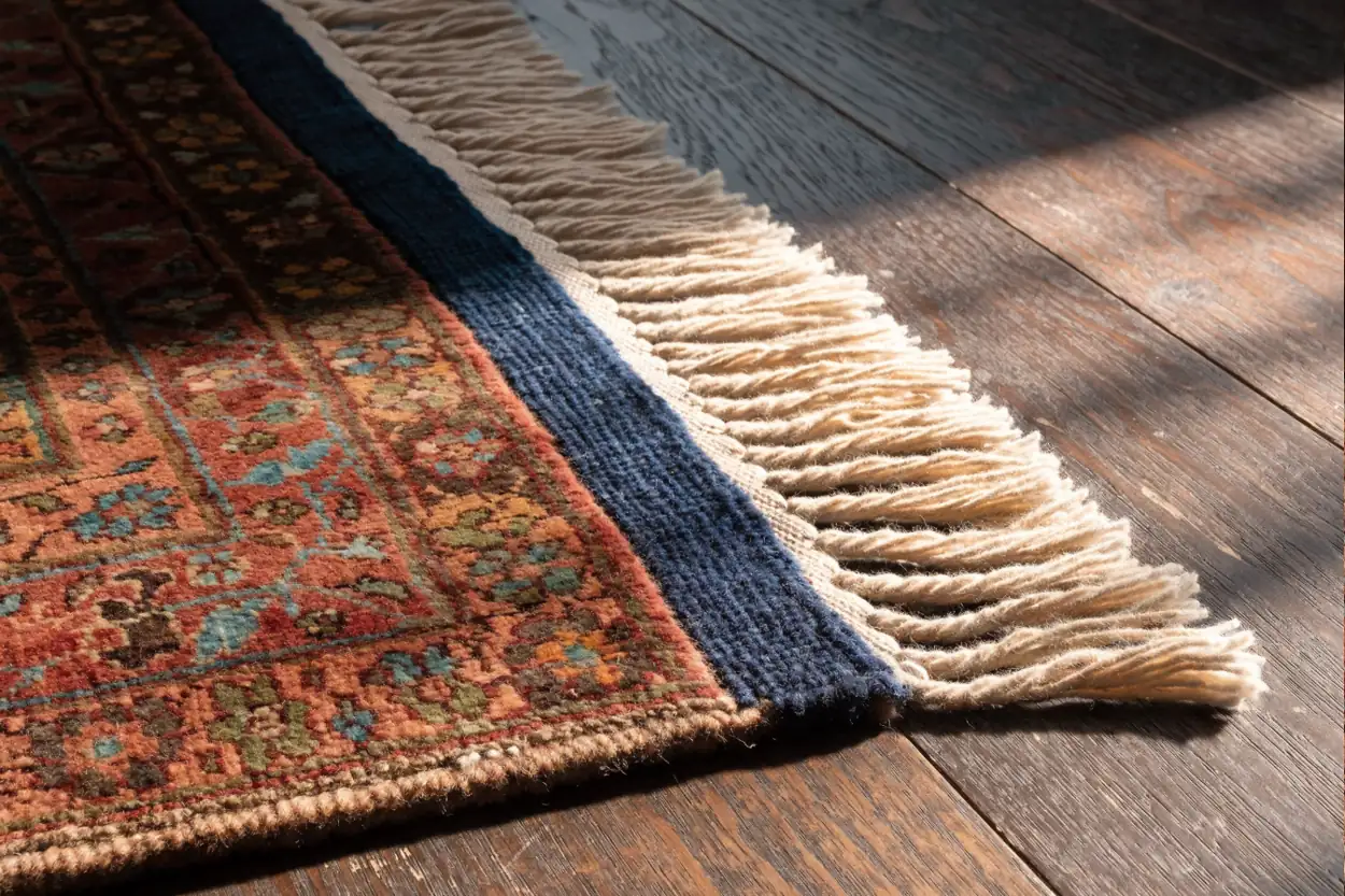 Coin de tapis restauré : franges neuves et lisière reprise